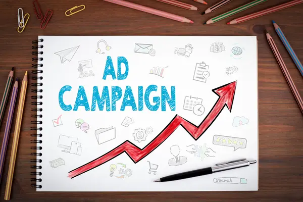 A notebook showing an 'Ad Campaign' sketch with a rising red growth arrow, representing successful Google Ads services and ROI.